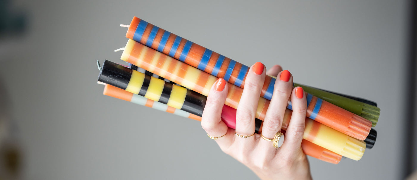 hand holding a bundle of stripe dinner candles
