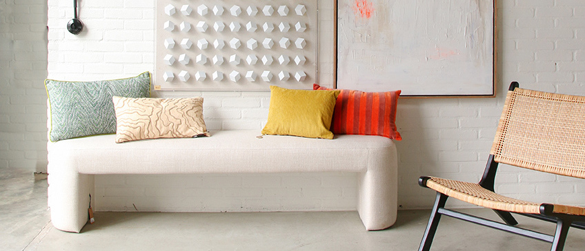 white bench with colourful cushions